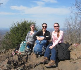 OEB students (from left) Emily Fusco, Laura Doubleday, and Hannah Broadley pose for a photo during a discussion of Sewall Wright's contributions to evolutionary biology atop Mt. Norwottuck in Mt. Holyoke Range State Park.
